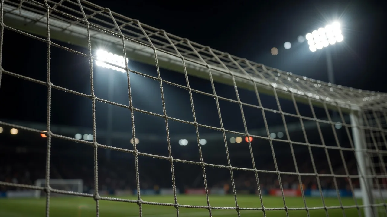 A goal net in extreme close-up under bright floodlights